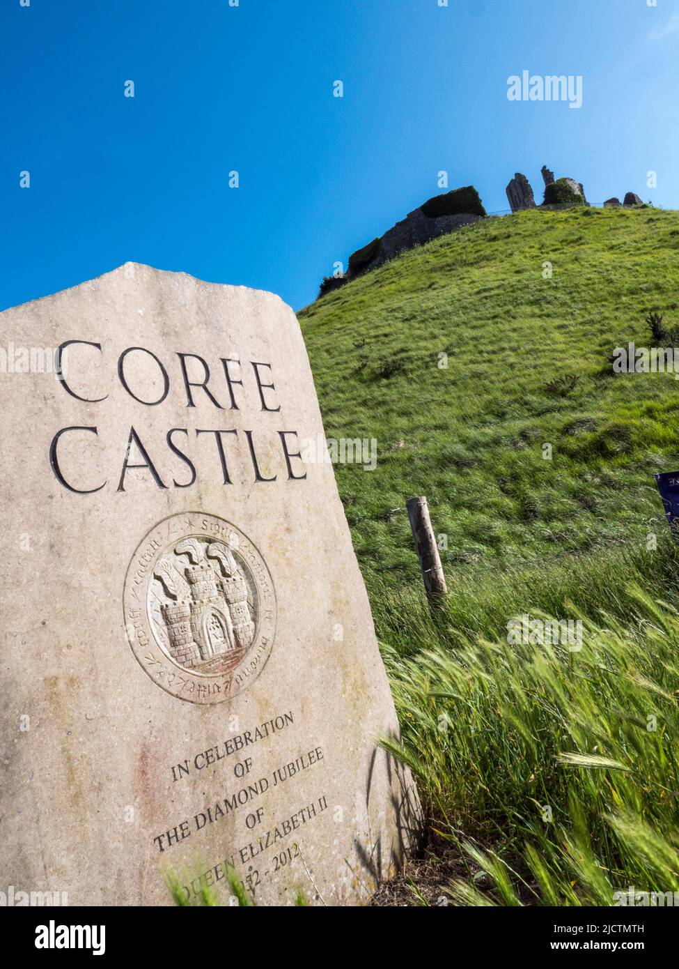 Marcador de piedra para el castillo de Corfe, Dorset, Reino Unido con el castillo en el fondo. Foto de stock