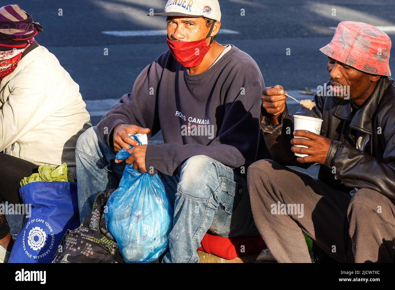 Personas sin hogar, africano, grupo, durante la pandemia de Covid en Ciudad del Cabo, Sudáfrica luciendo el concepto de máscara de cara pobreza, dificultad, vida dura Foto de stock