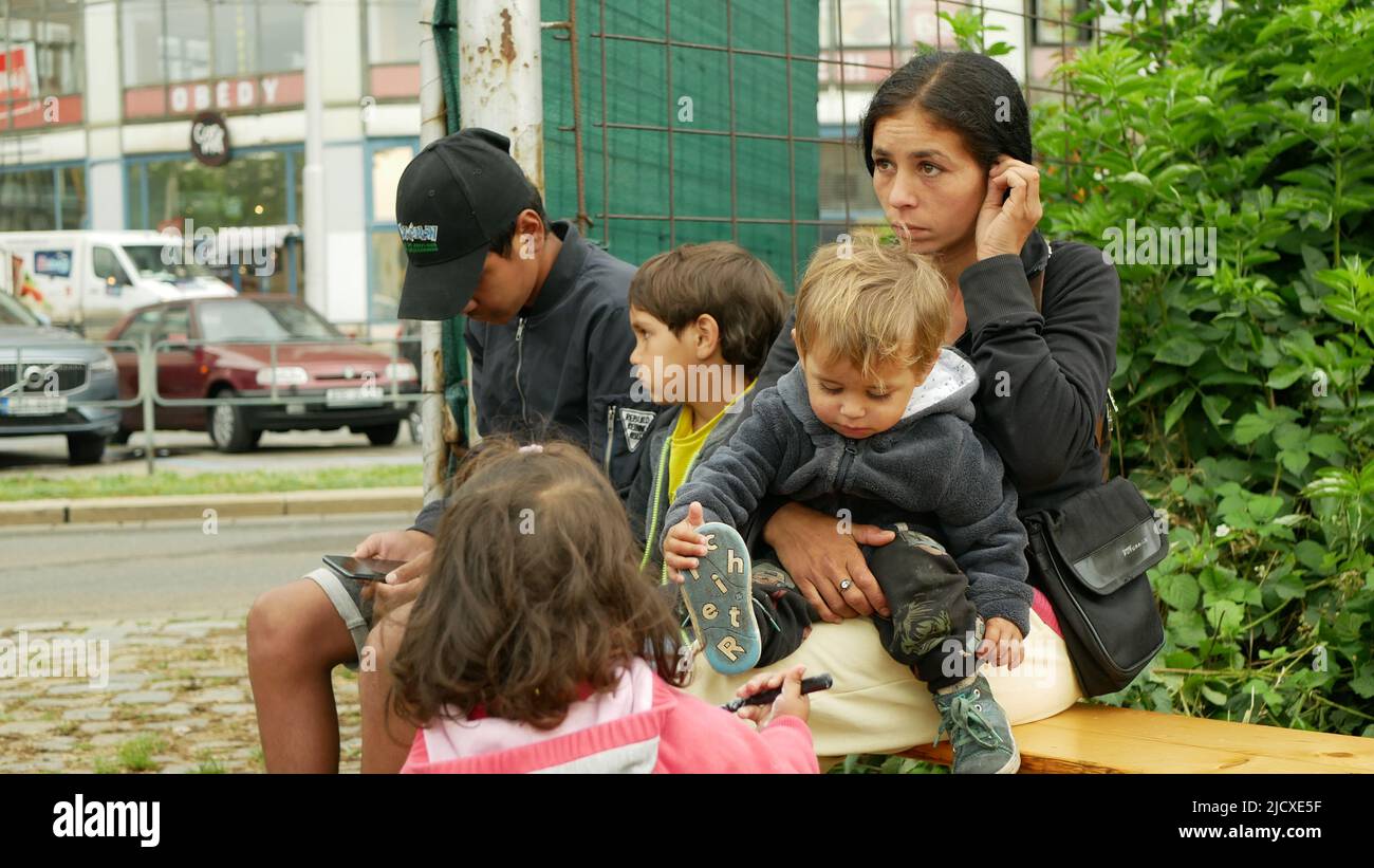 Inmigrantes refugiados Ucrania Detención Gitanos Campamento Gitano Personas sentadas en un banco familia niños niños niños niños niños niños niños romaníes colocación de madre en Brno Ukrain Foto de stock