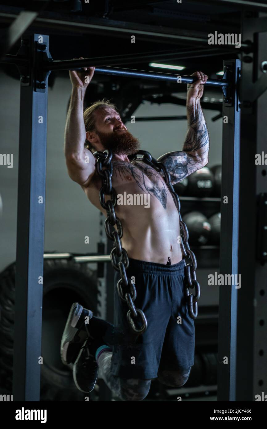 Hombre musculoso posando en el gimnasio con un cinturón atlético. concepto  de fitness.