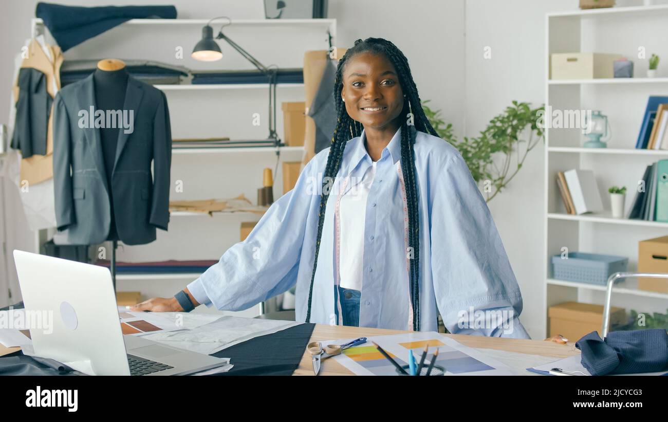 Retrato de una mujer afroamericana, una diseñadora de moda exitosa en un taller ligero y acogedor. Hermosa gente exitosa en el lugar de trabajo. Concepto Foto de stock