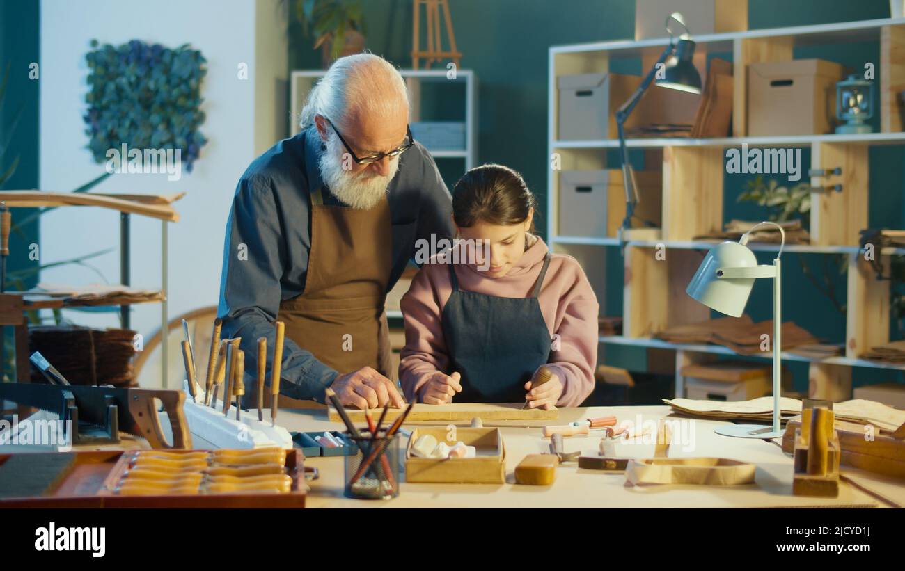 Abuelo carpintero con nieta Trabajo con madera para crear artículos Foto de stock