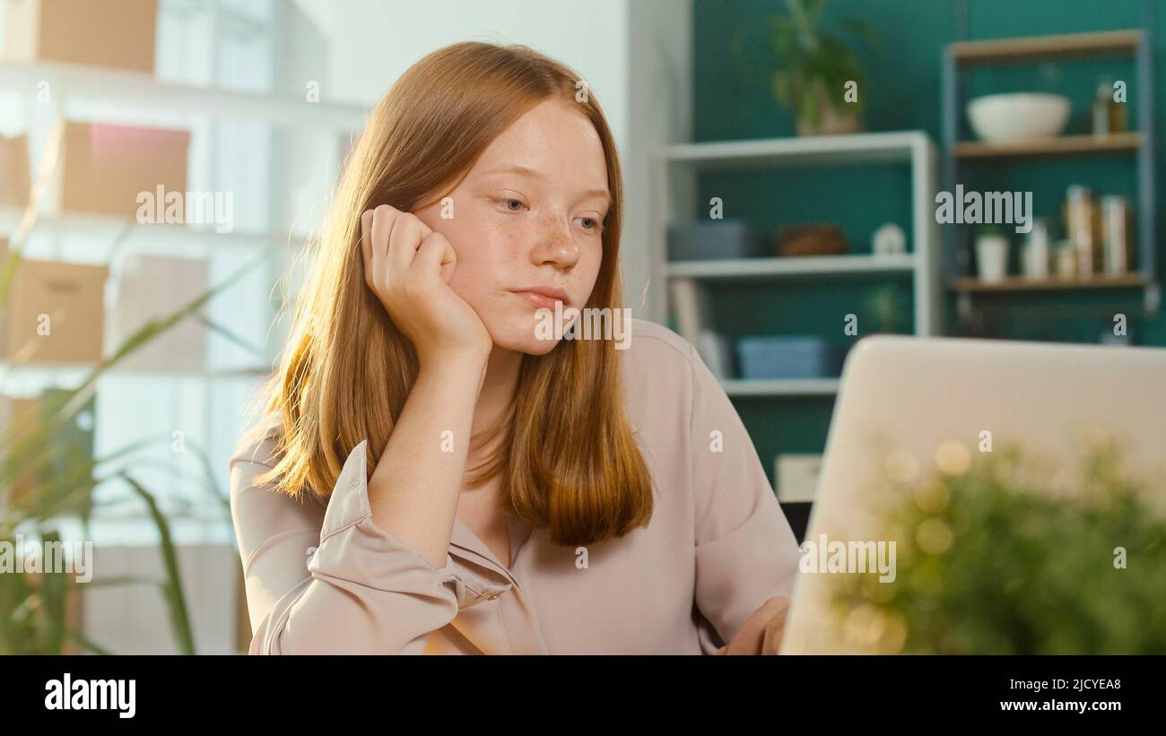 Adolescente Cansado Schoolgirl mientras estudiaba en línea en un ordenador portátil. Abrumado Foto de stock