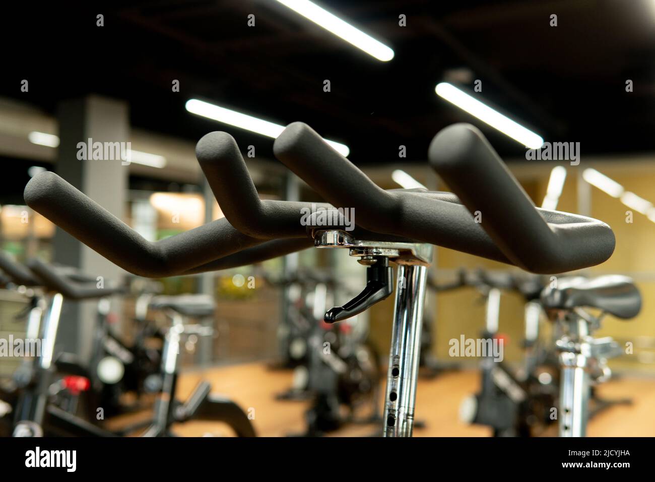 Simulador gimnasio estacionario moderno manillar bicicleta gimnasio musculación sala de ejercicios, para hacer ejercicio en bicicleta desde el cuerpo, paseo en el interior. Formador Foto de stock