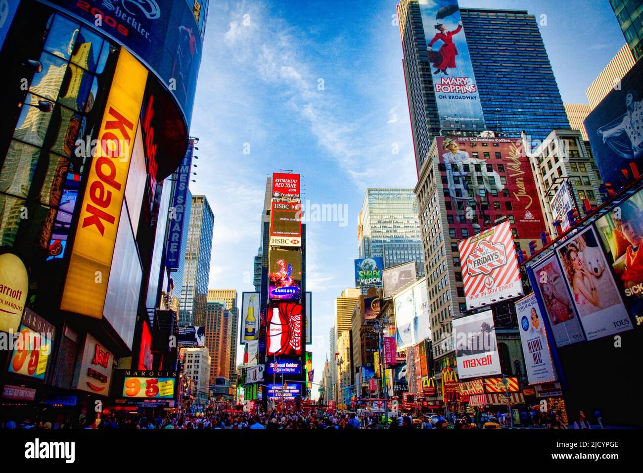 Times Square comienza a iluminarse a medida que el día se envejece en la ciudad de Nueva York, Nueva York. Foto de stock