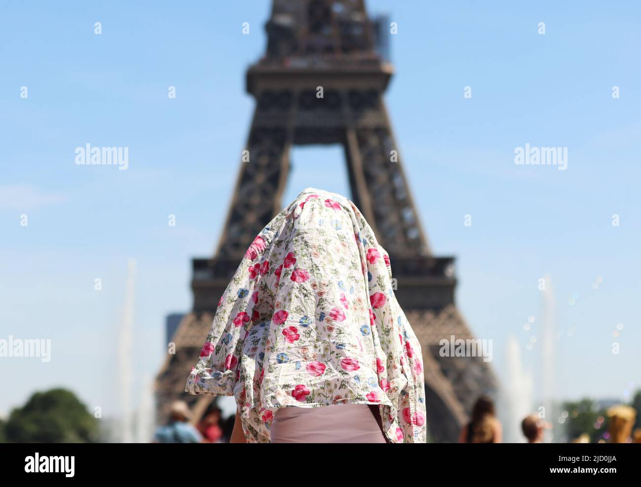 París, Francia. 16th de junio de 2022. Una persona es vista cubriendo la  cabeza con una blusa cerca de la Torre Eiffel en París, Francia, el 16 de  junio de 2022. Meteo