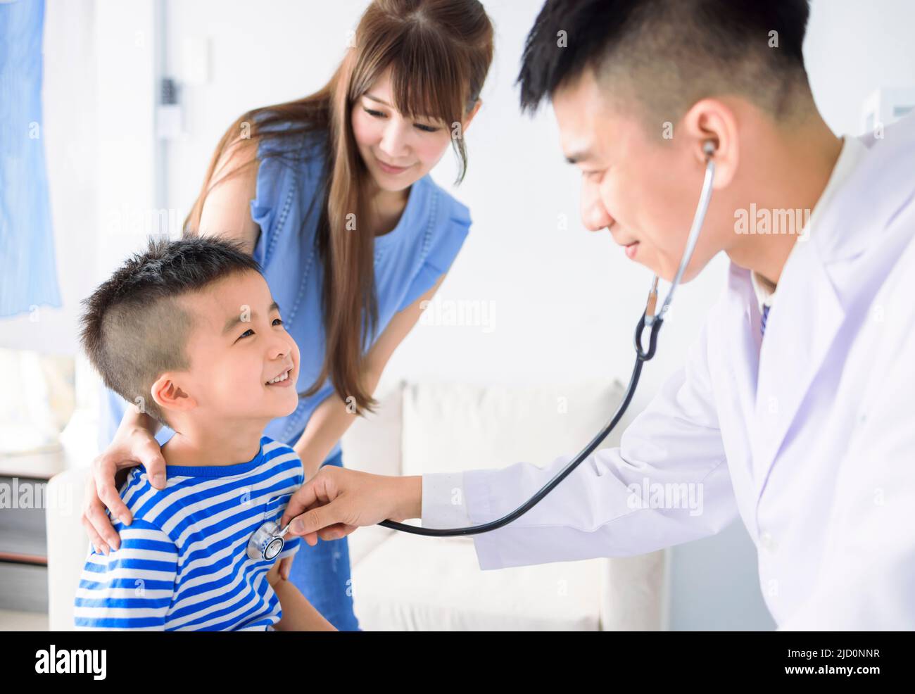 El pediatra masculino realiza un examen de estetoscopio niño niño niño niño niño niño niño niño niño niño visita al médico con la madre Foto de stock