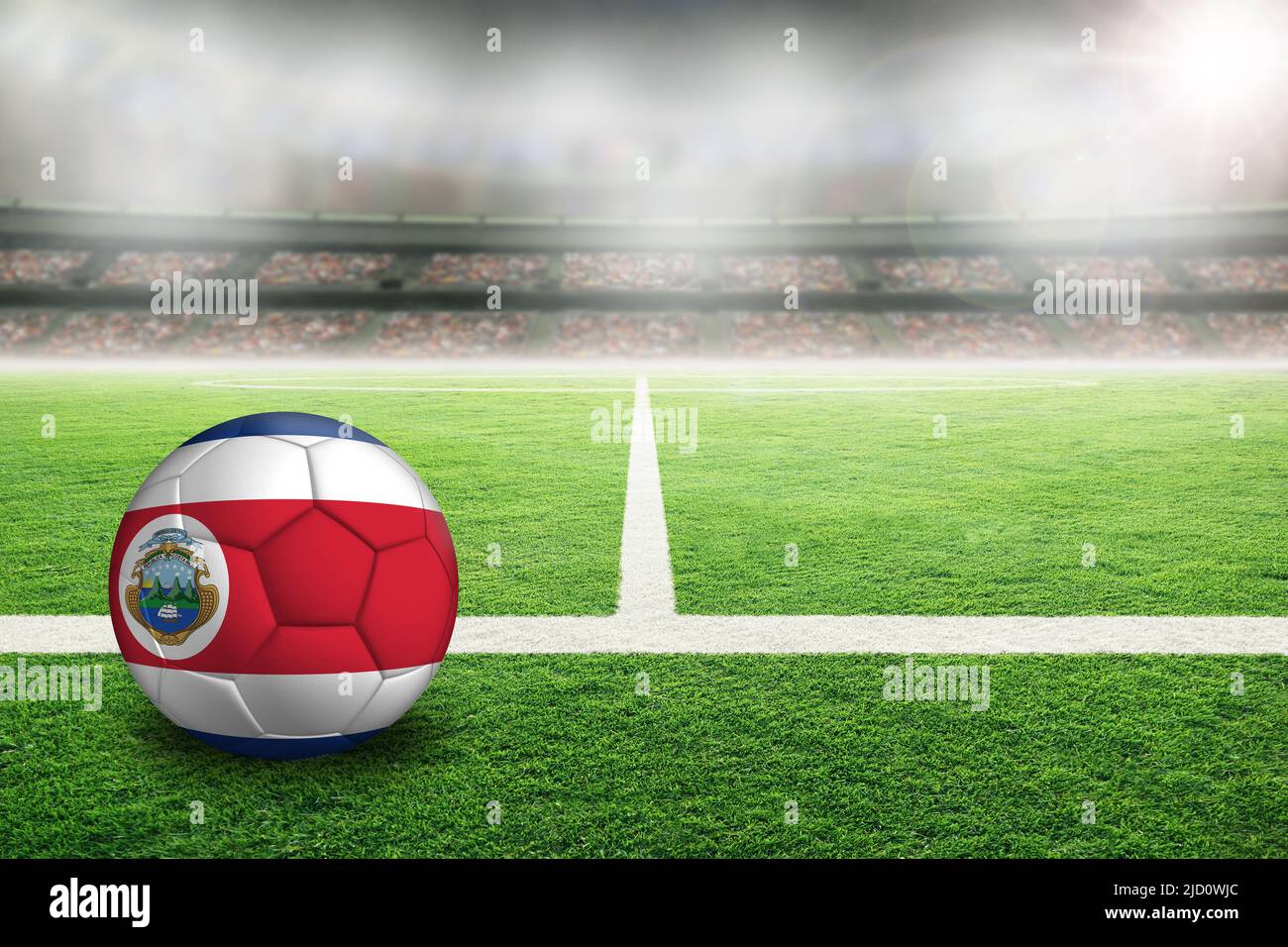 Fútbol de Costa Rica en un estadio al aire libre con mucha luz y bandera costarricense pintada. Concéntrate en el primer plano y en el balón de fútbol con poca profundidad de campo Foto de stock