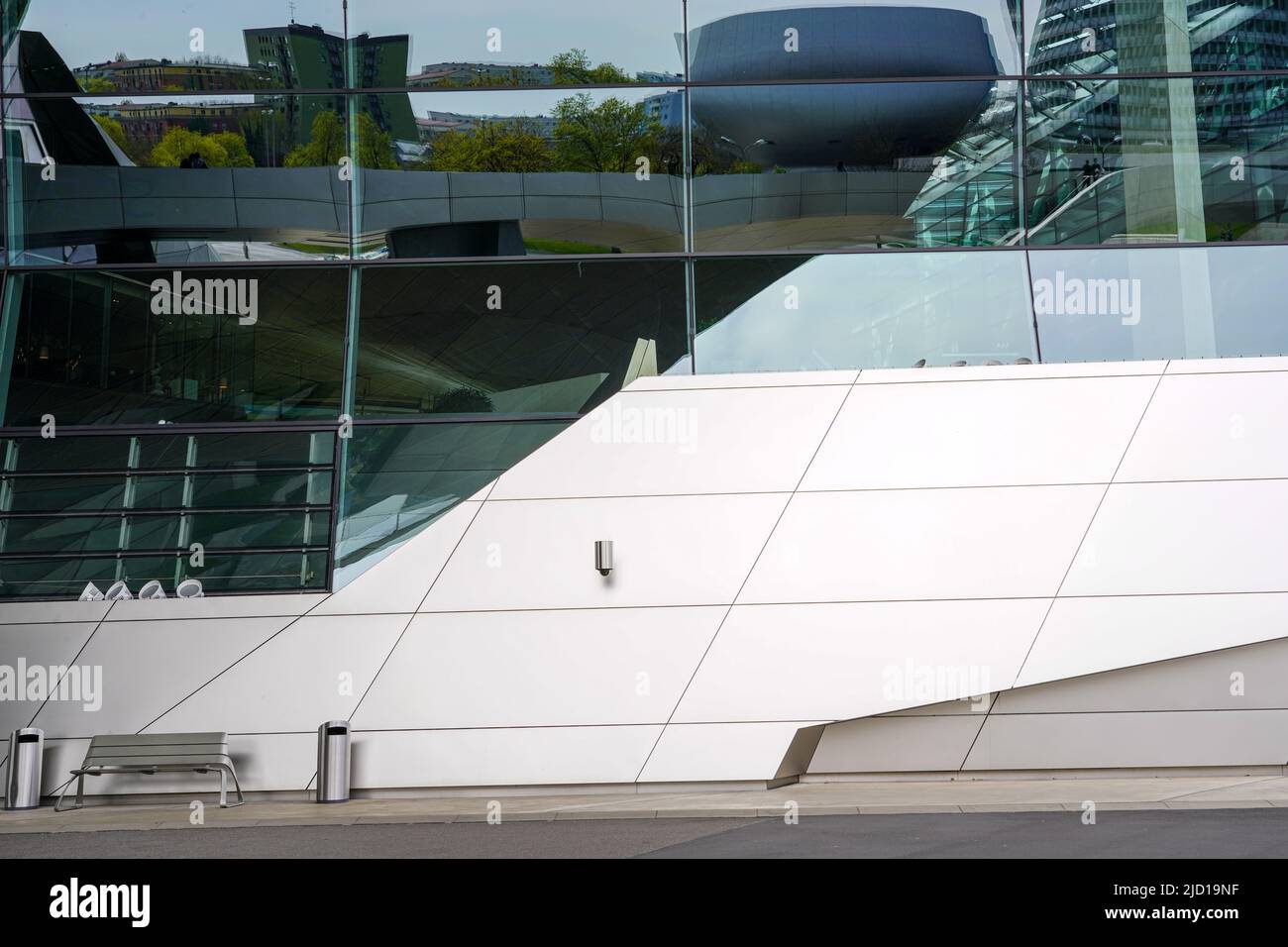 Reflexiones del Museo BMW y sus alrededores en la fachada de cristal de BMW World Munich, Alemania, 22.4.22 Foto de stock