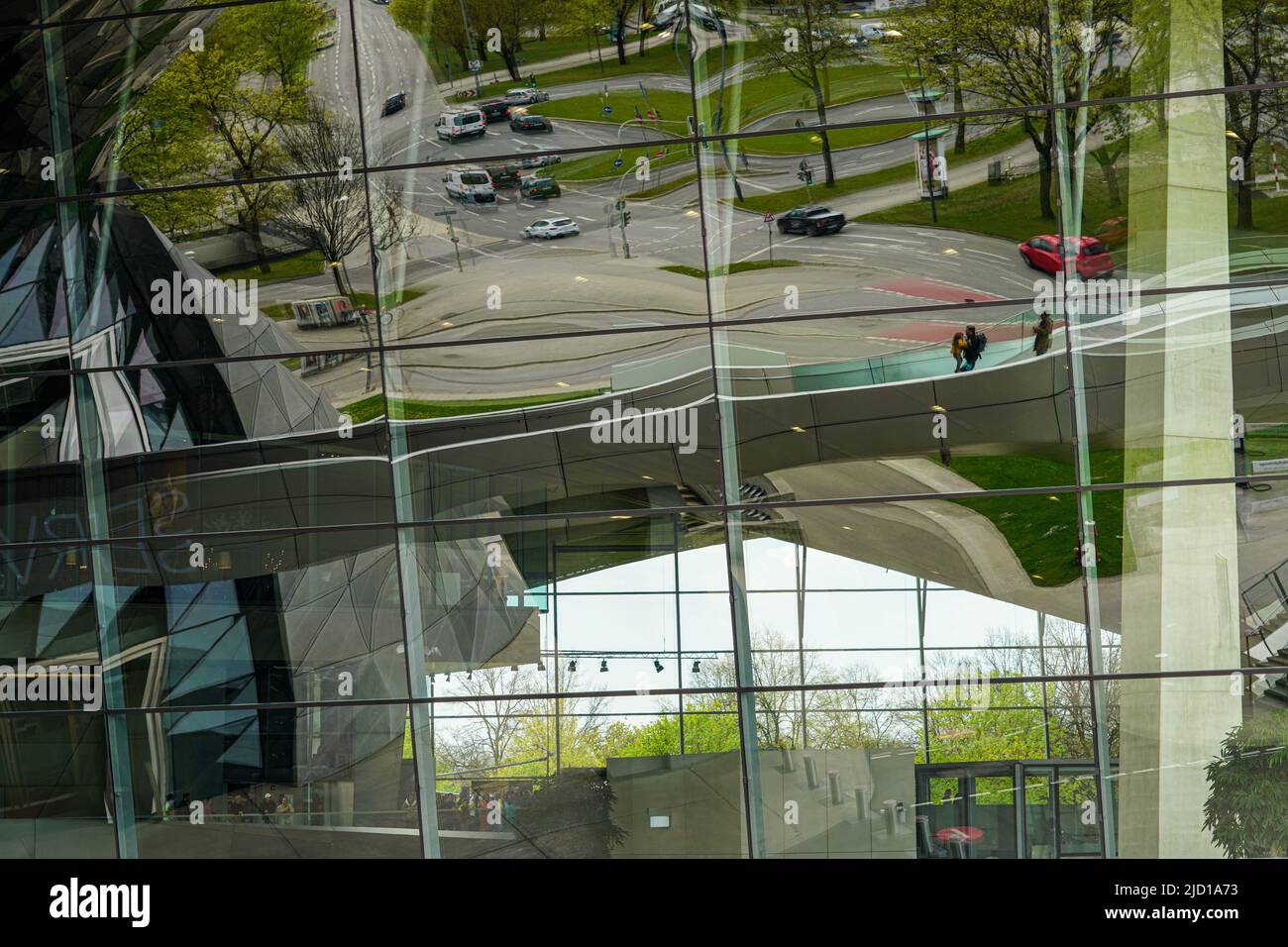 Reflexiones del Puente DE LAS TRIAS y sus alrededores en la fachada de cristal de BMW World Munich, Alemania, 19.4.22 Foto de stock