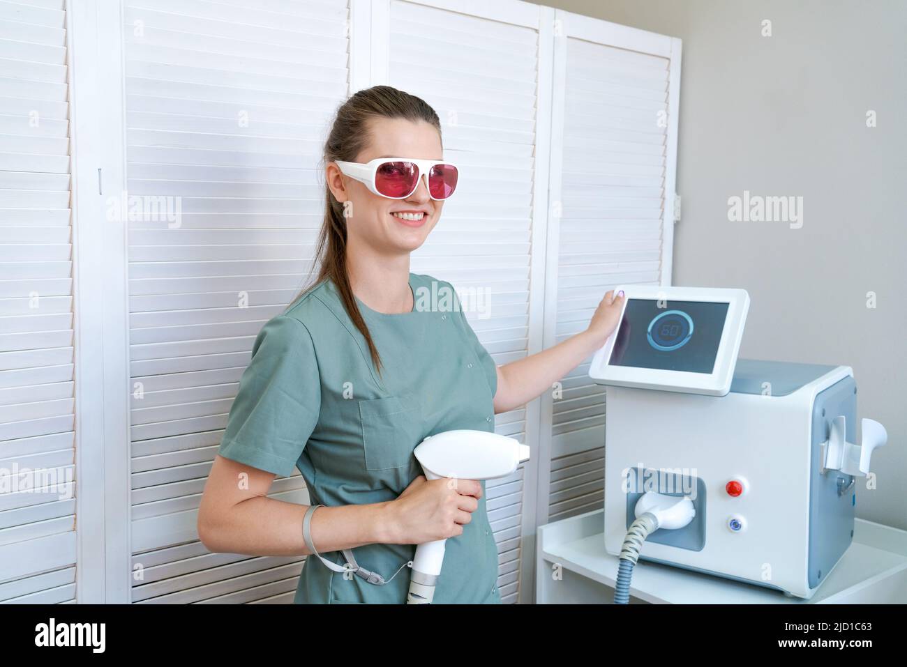 Sonriente mujer cliente en gafas protectoras en el procedimiento de  depilación. Eliminación del vello con láser en la mano femenina. Concepto  de cosmetología profesional Fotografía de stock - Alamy