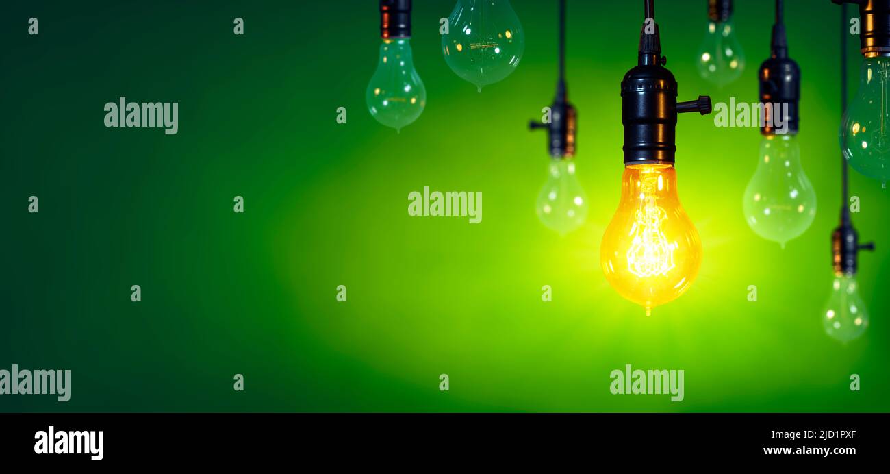 Bombilla encendida entre bombillas apagada en fondo verde - Concepto de inspiración y liderazgo Foto de stock