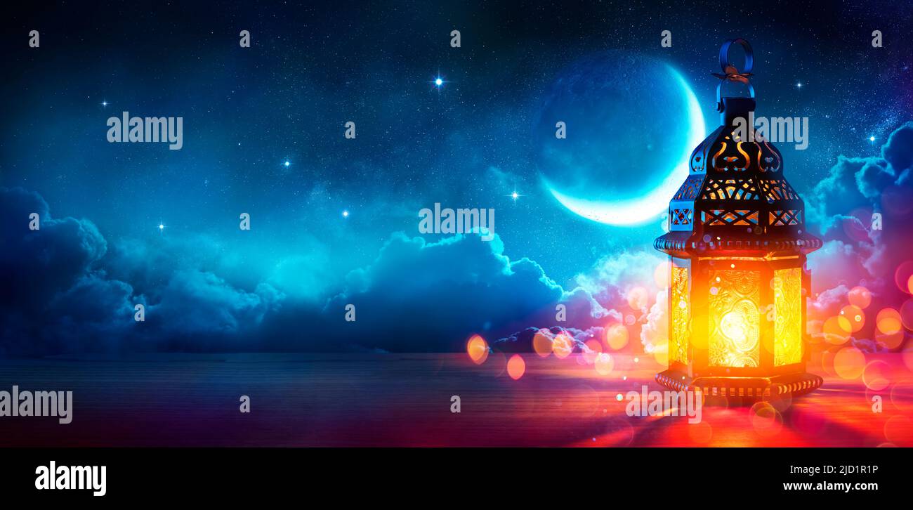 Ramadan Kareem - Luna y Linterna Arábiga con Cielo Azul por la Noche con Luces Abstractas Desenfocadas - Eid Ul Fitr Foto de stock