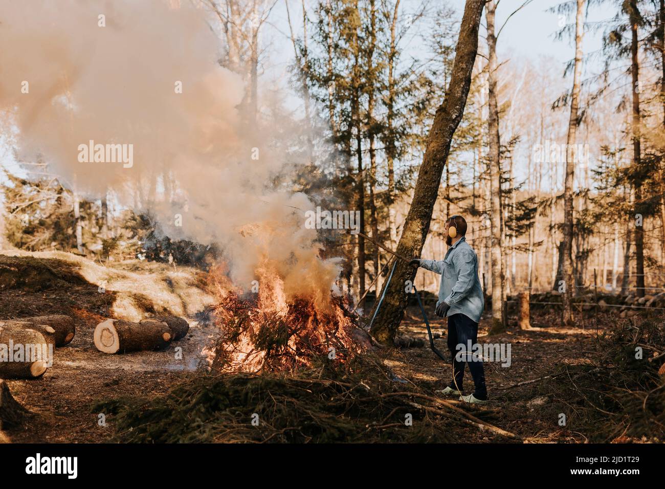 Hombre quemando ramas en el bosque Foto de stock