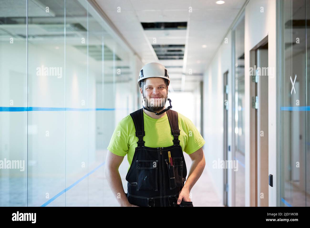 Trabajador sonriente de pie en el pasillo Foto de stock
