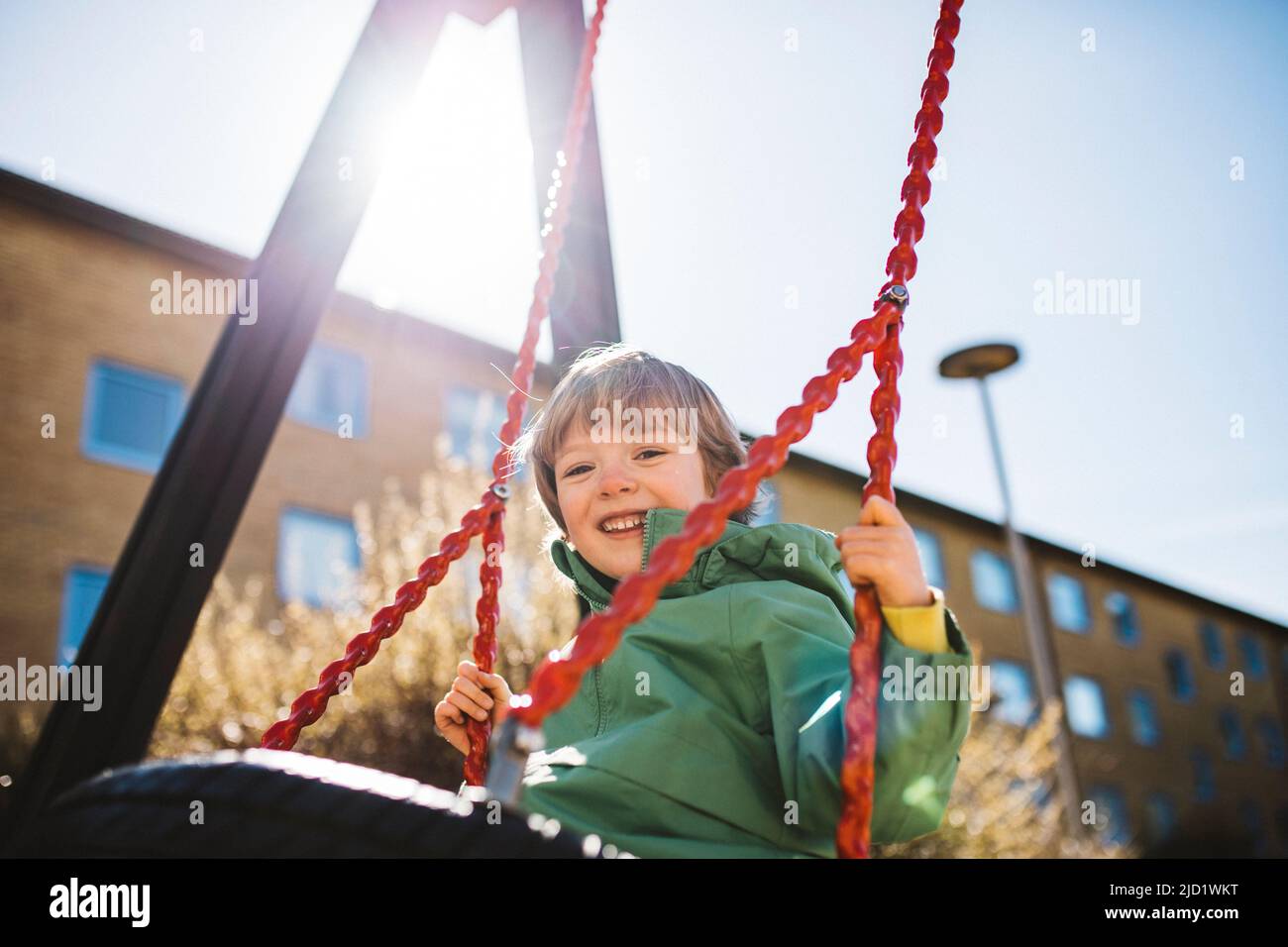 Chico sonriente en swing Foto de stock