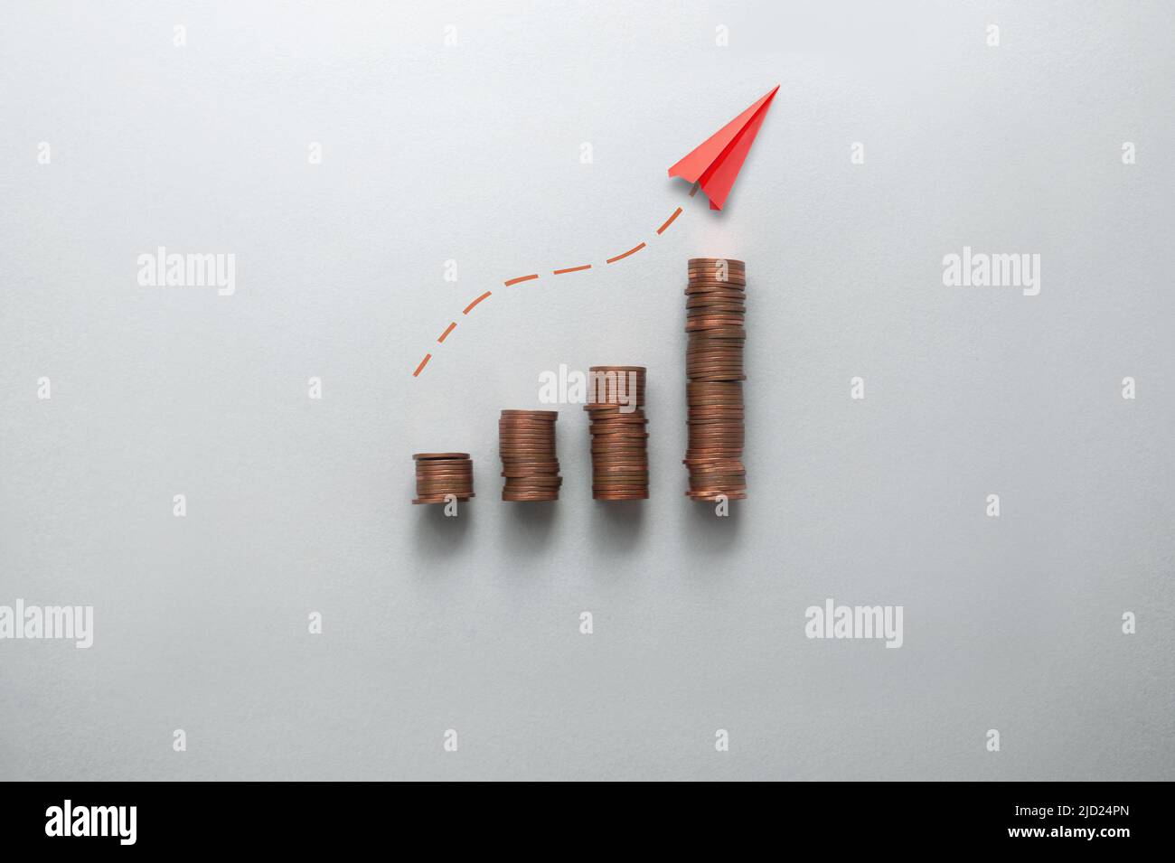 Concepto de aumento de la inflación, los costes y los precios, gráfico de negocios pilas de monedas con el papel de avión que se mueve hacia arriba Foto de stock