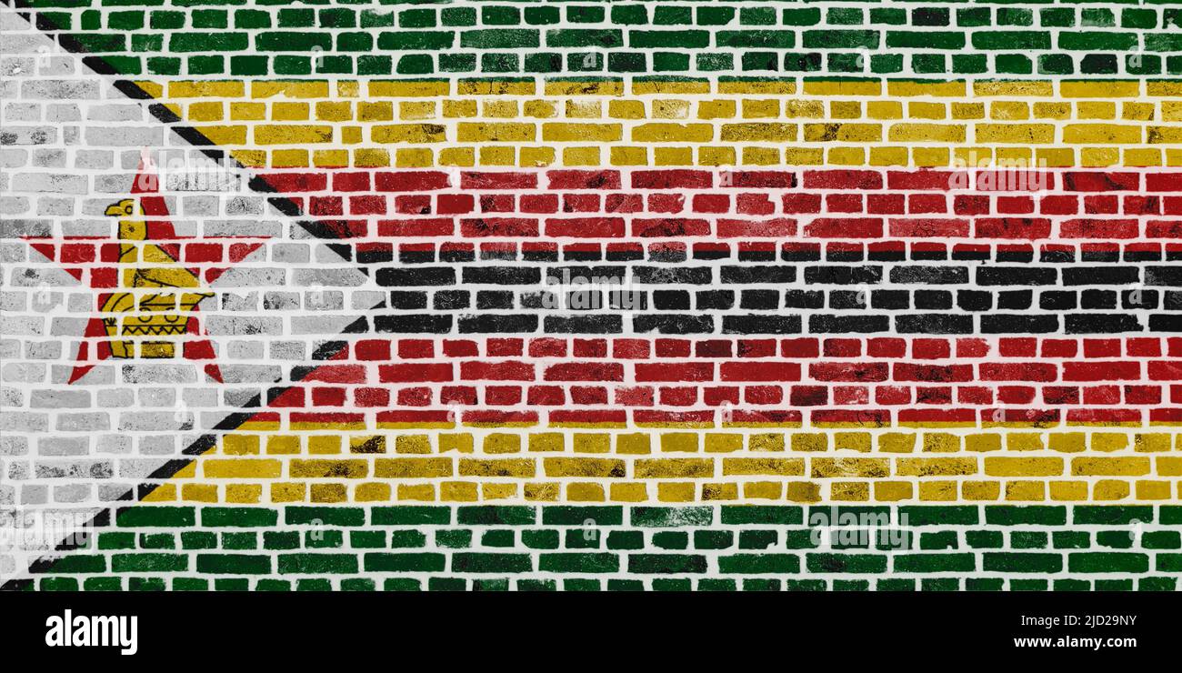 Primer plano en una pared de ladrillo con la bandera de Zimbabwe pintada en ella. Foto de stock