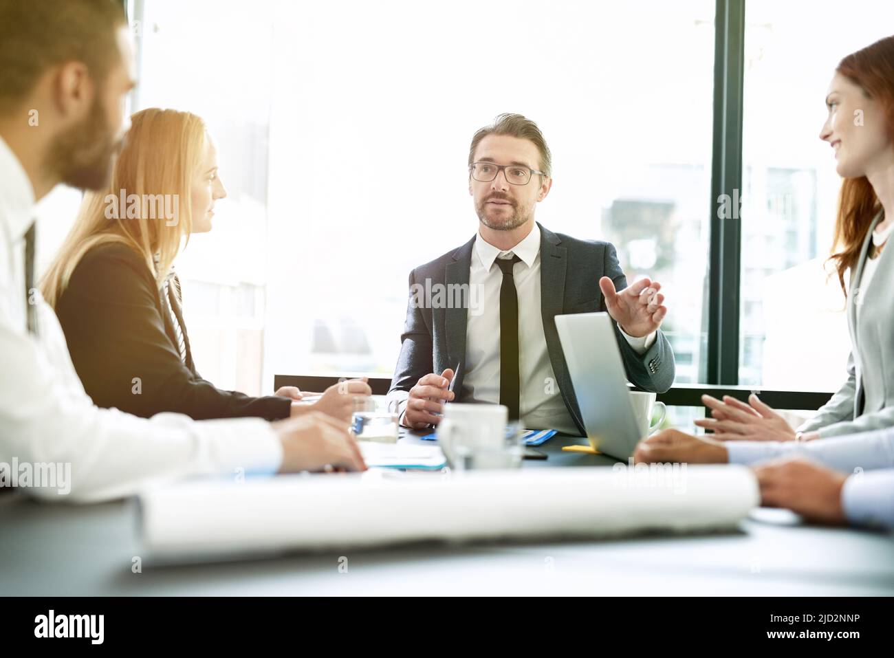 Facilitar su reunión con una dirección clara. Fotografía de un equipo de ejecutivos que tiene una reunión formal en una sala de juntas. Foto de stock