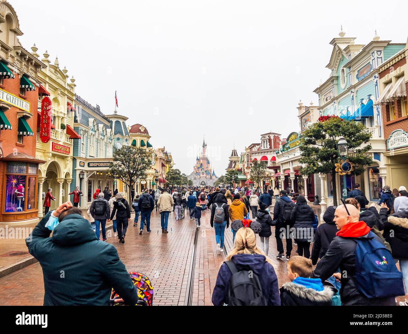 París, Francia - 04/05/2022: Castillo de la Bella Durmiente con tiempo nublado. La gente camina a los edificios famosos e icónicos de los parques de Disneyland. Foto de stock