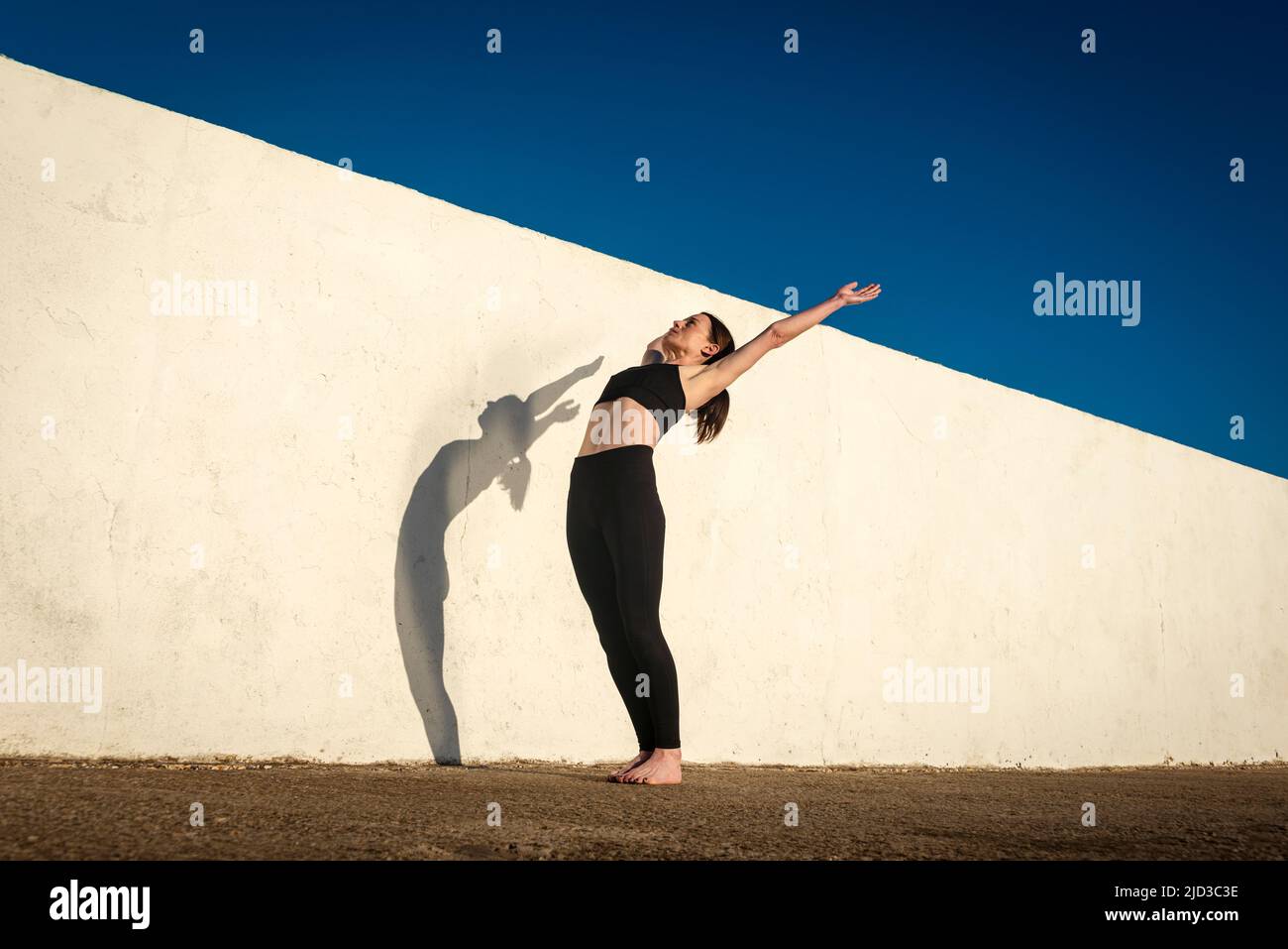 Ajuste mujer deportiva haciendo ejercicio de estiramiento fuera. Foto de stock