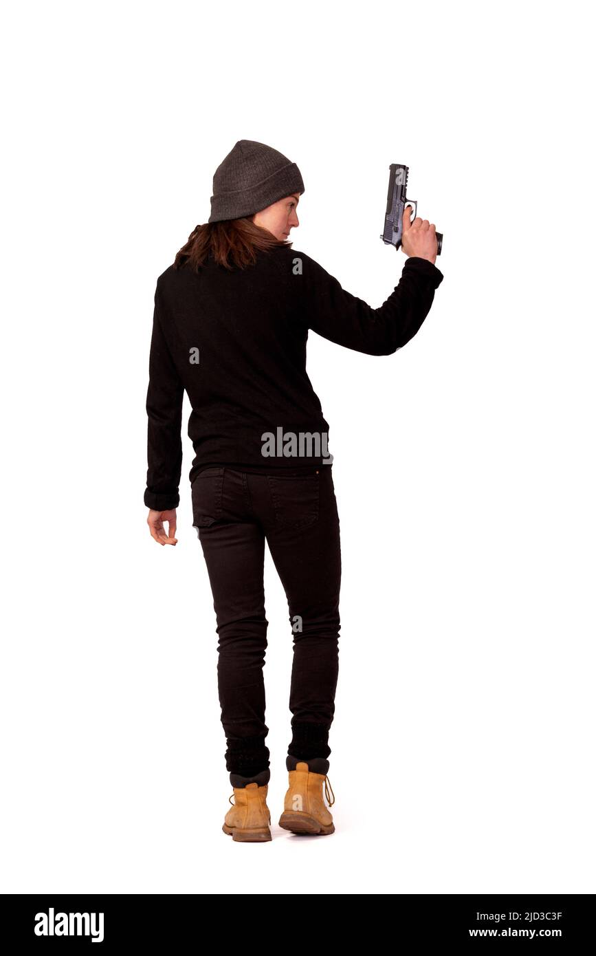 Mujer vestida de negro sosteniendo una pistola Foto de stock