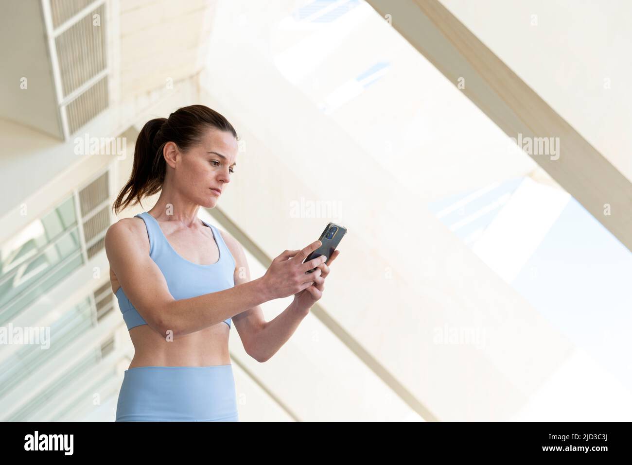 ajuste mujer deportiva comprobando su smartphone, aplicación de fitness. Foto de stock