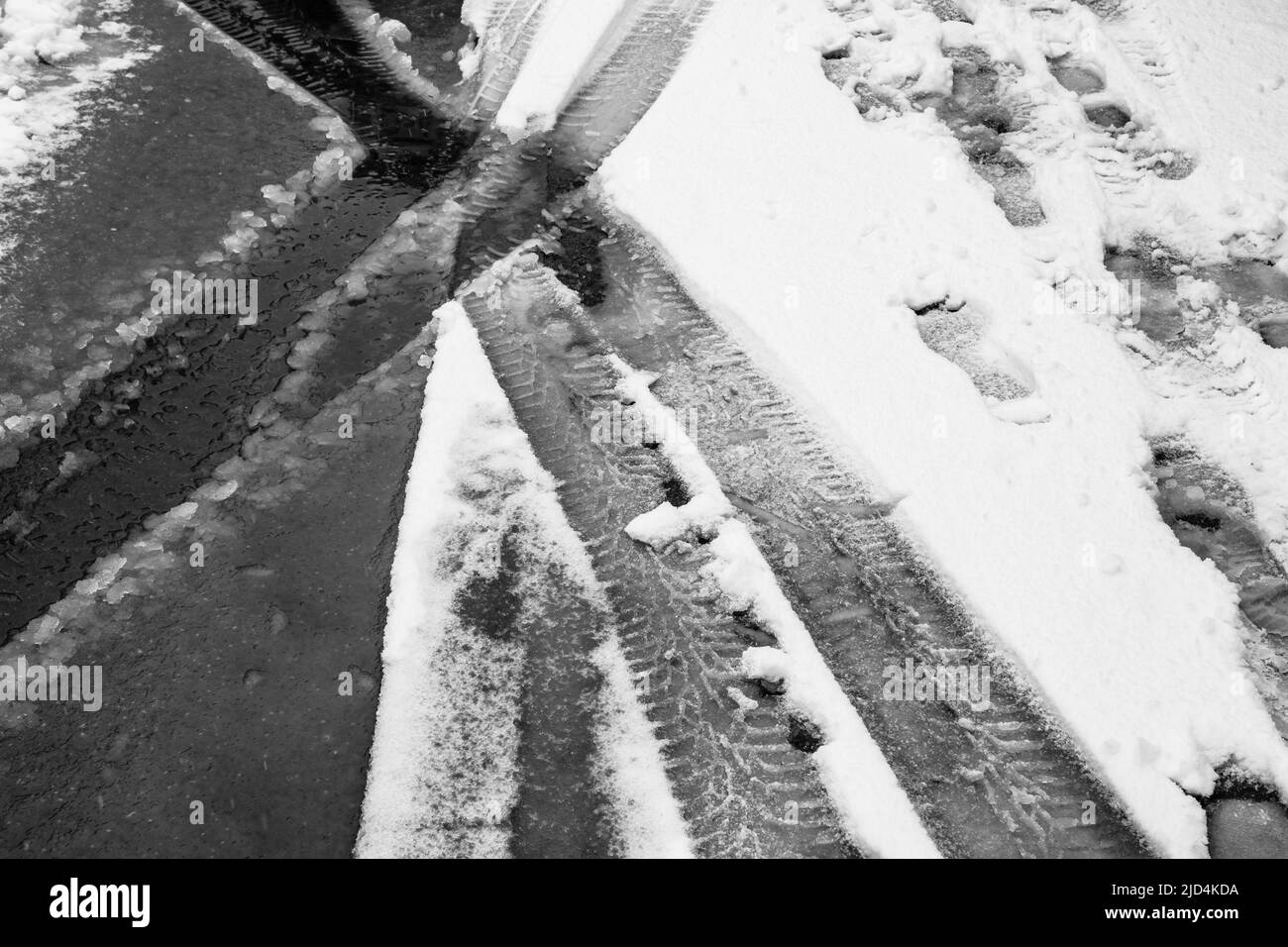 Coches y senderos en la nieve, camino nevado. Foto de stock