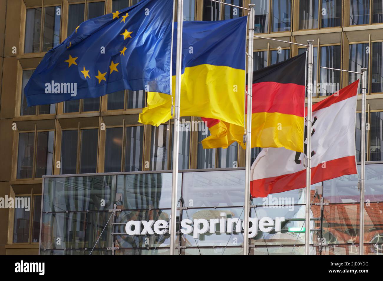 Entrada de la editorial Axel Springer con cuatro banderas: UE, Ucrania, Alemania, Berlín. Foto de stock