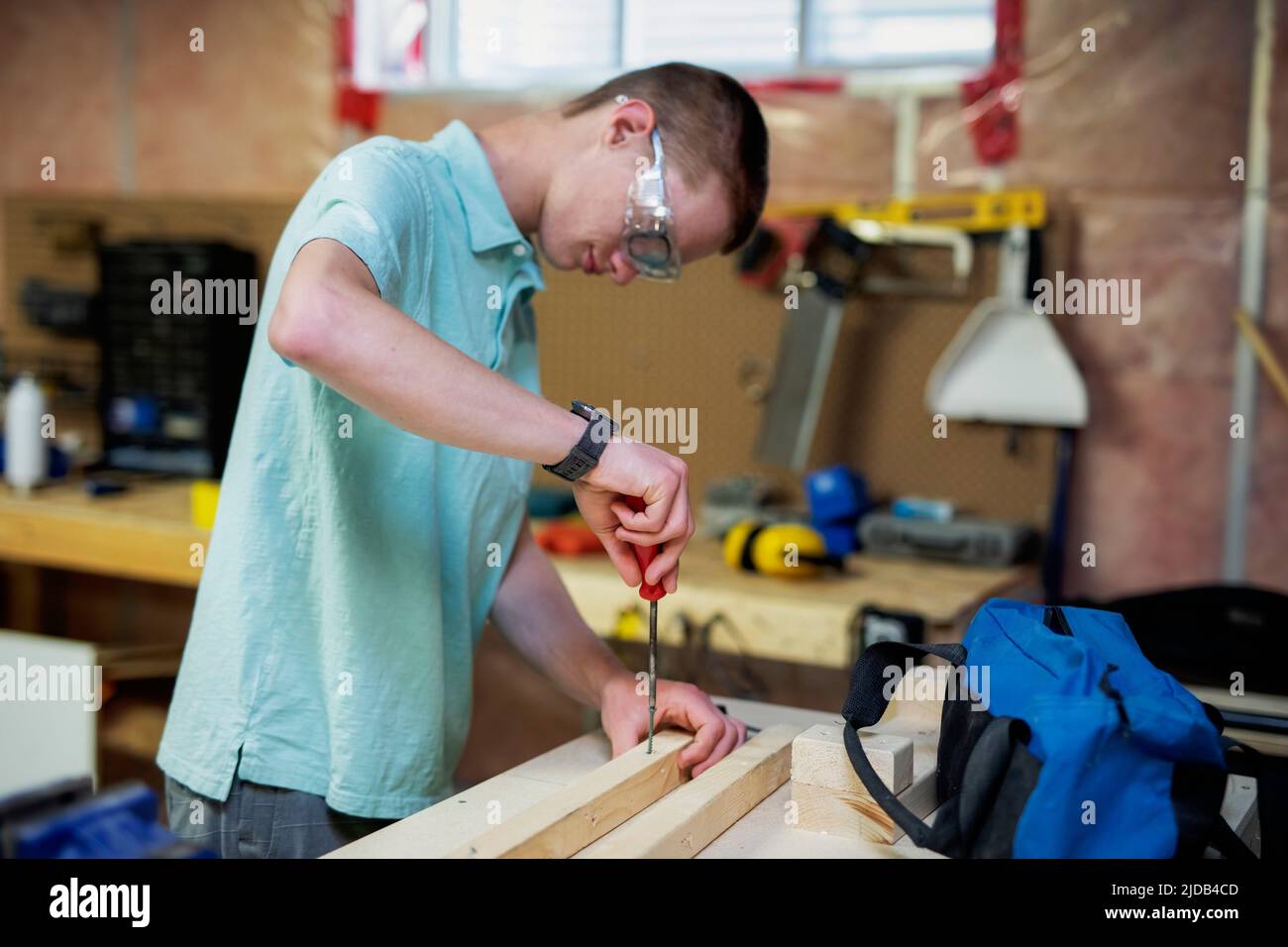 Joven haciendo carpintería en su sótano; Edmonton, Alberta, Canadá Foto de stock