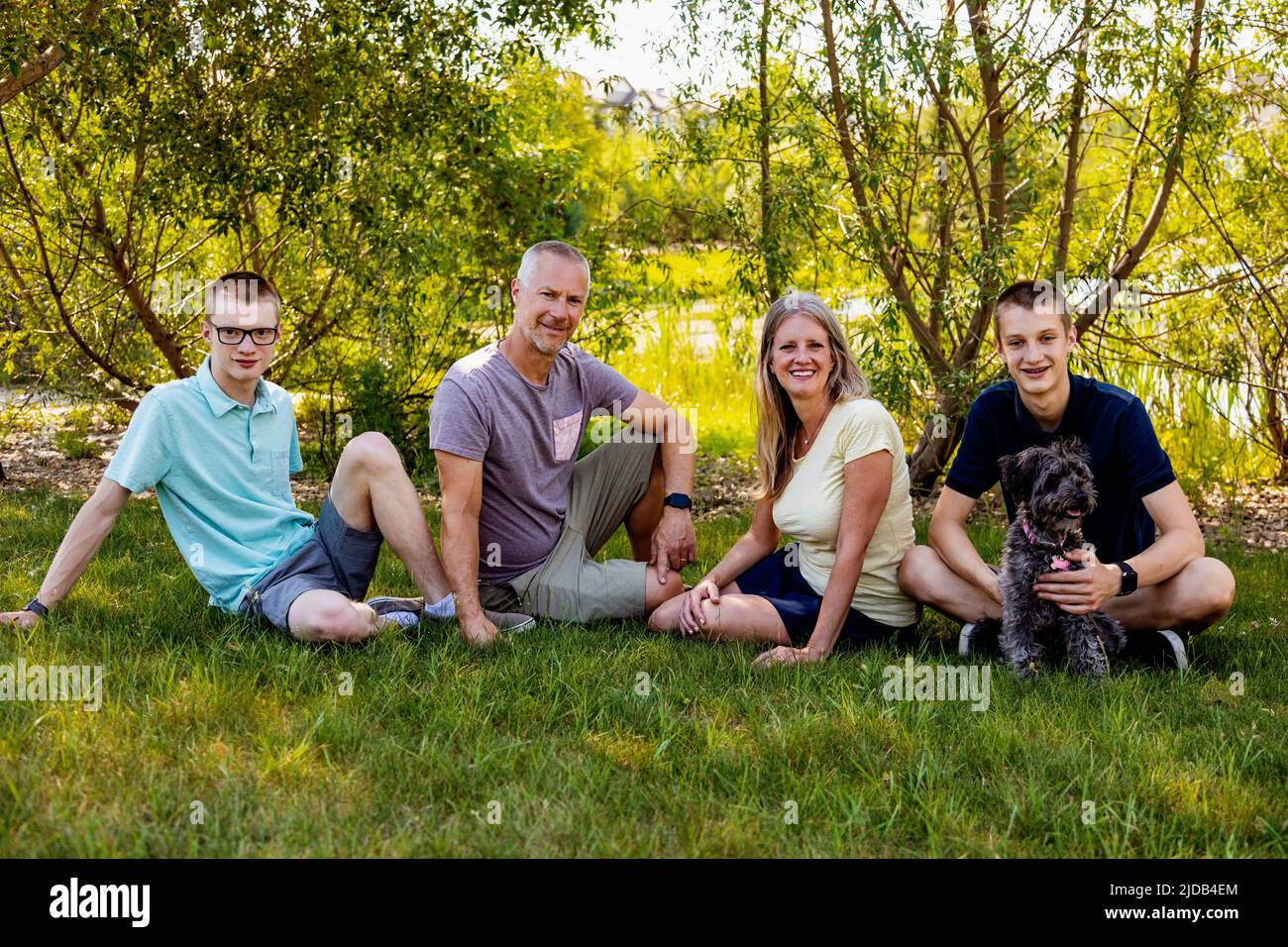 Retrato al aire libre de la familia en un parque con dos hijos adolescentes y un perro; Edmonton, Alberta, Canadá Foto de stock
