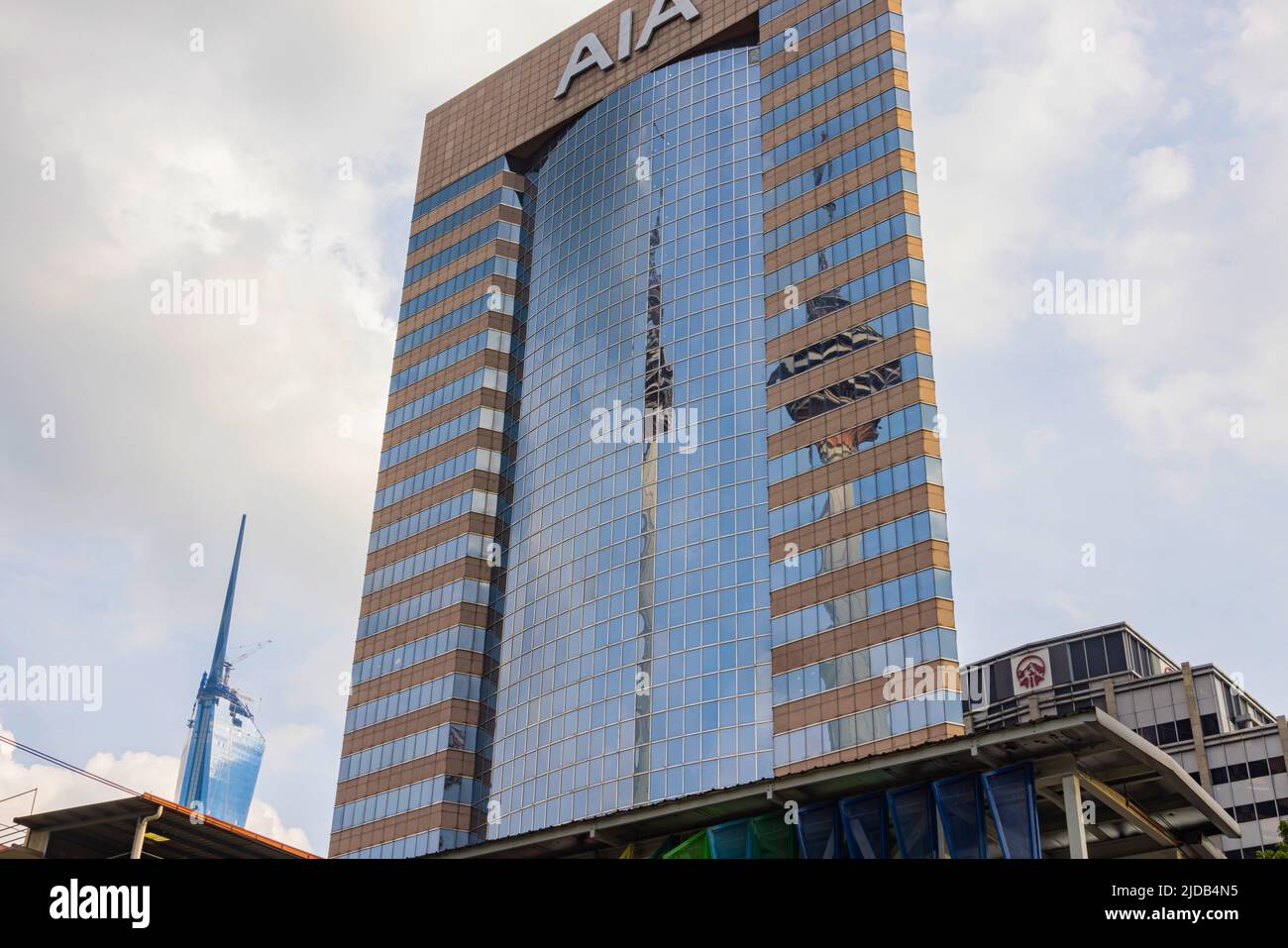 Kuala Lumpur, Malasia - junio de 18. 2022: Torre Menara que se refleja en la fachada de cristal del edificio AIA. En el fondo el rascacielos Merdeka 118. Foto de stock