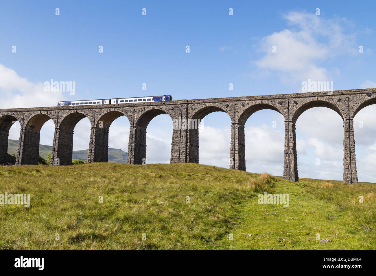 Un tren pasa sobre el espectacular viaducto de Ribblehead en el asentamiento del ferrocarril de Carlisle en junio de 2022 sobre el valle de Ribble. Foto de stock