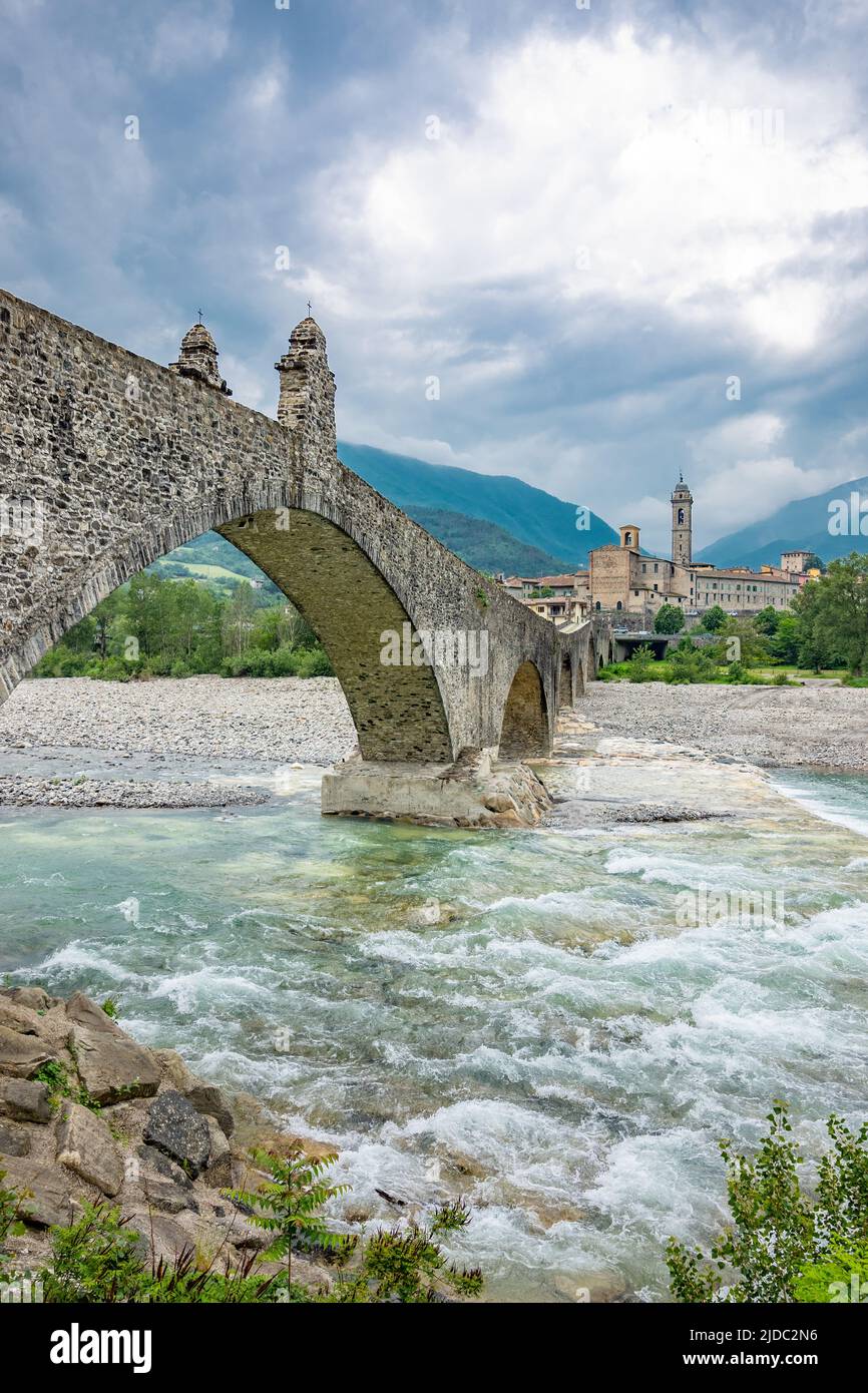 Bobbio, Italia, el Puente Viejo (también conocido como el Puente del Diablo) sobre el río Trebbia, con el país en el fondo Foto de stock
