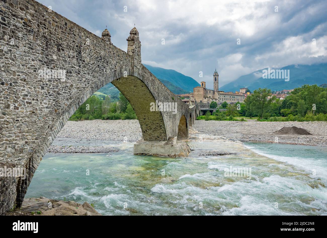Bobbio, Italia, el Puente Viejo (también conocido como el Puente del Diablo) sobre el río Trebbia, con el país en el fondo Foto de stock