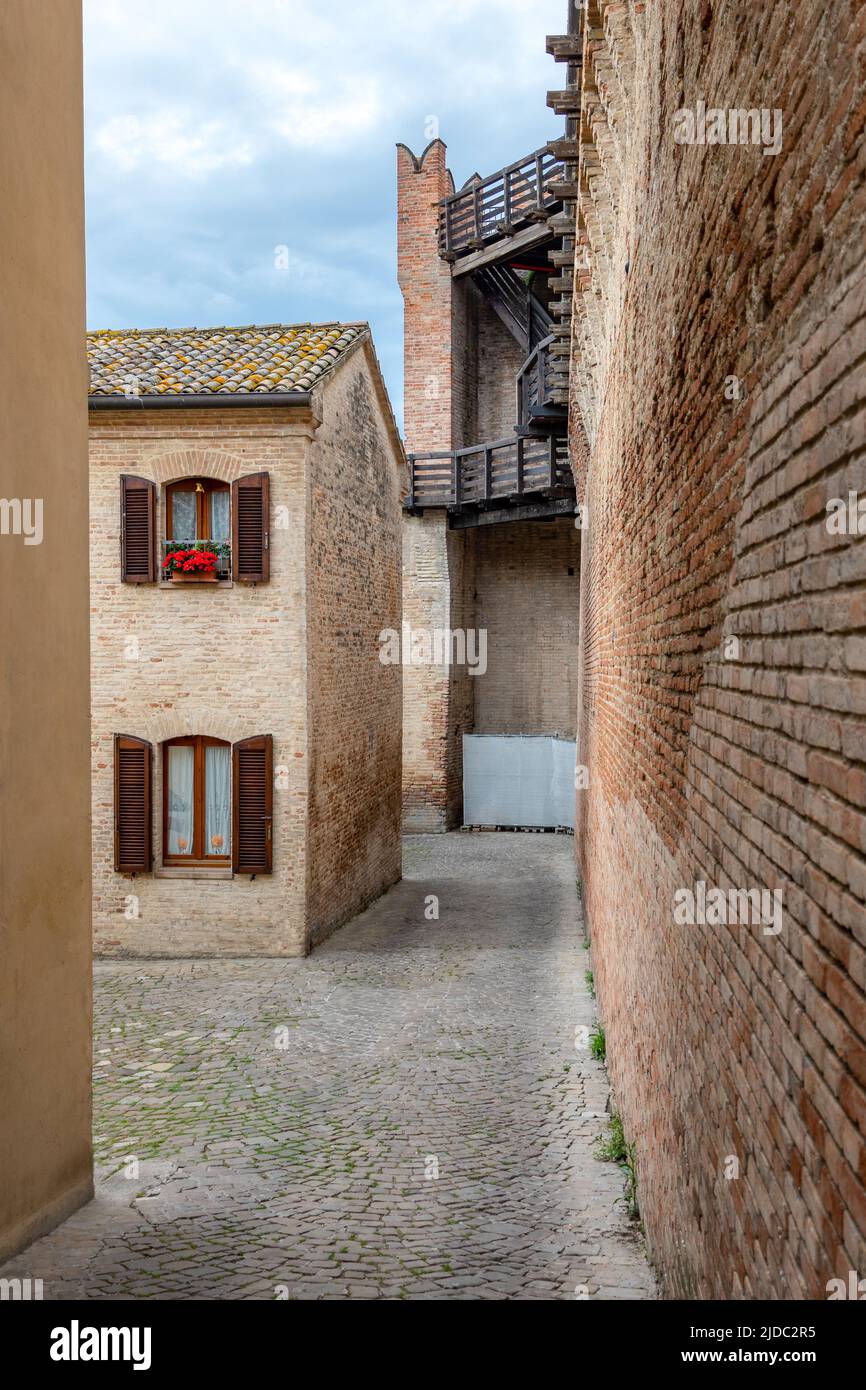 Gradara, Italia, con vistas a las tradicionales casas de ladrillo frente a las murallas medievales Foto de stock