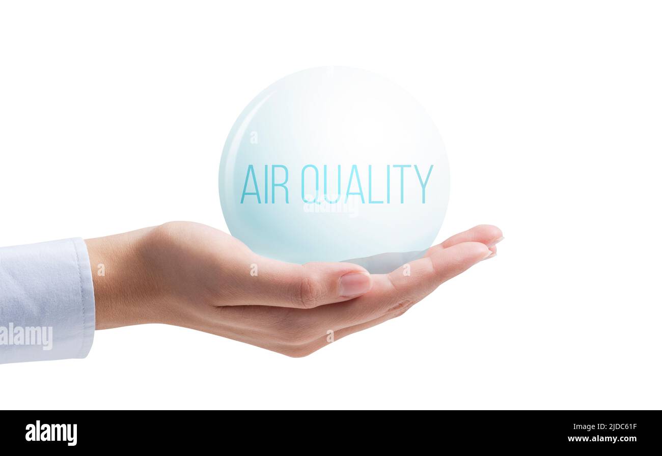 Mano que sostiene una burbuja de aire limpio: Control del índice de calidad del aire aislado sobre fondo blanco Foto de stock