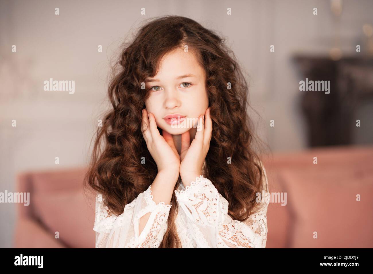 Bonita hermosa niña de 10-12 años con largo pelo rubio oscuro en la habitación de cerca. Retrato de joven adolescente. Infancia. Foto de stock