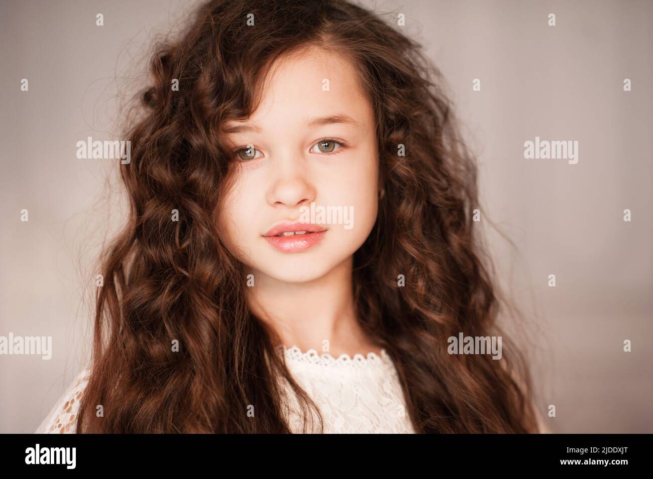 Bonita hermosa niña de 10-12 años con largo pelo rubio oscuro en la habitación de cerca. Retrato de joven adolescente. Infancia. Foto de stock