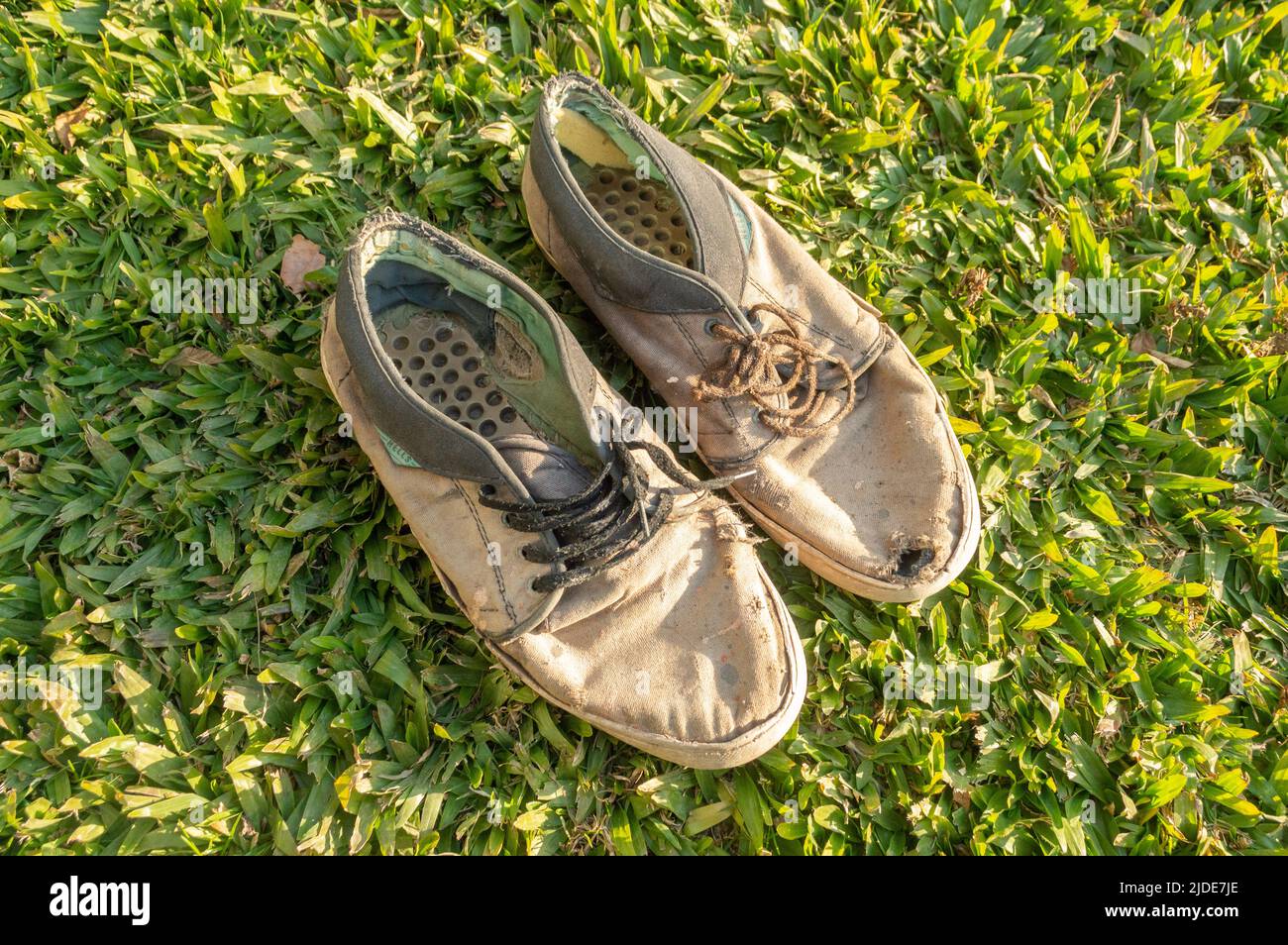zapatos para hombres viejos y rotos en el césped Foto de stock