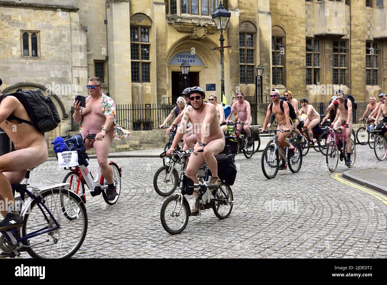 Ciclistas en World Naked Bike Ride en Bristol 2022 en bicicleta por el centro de la ciudad por la biblioteca central, Reino Unido Foto de stock