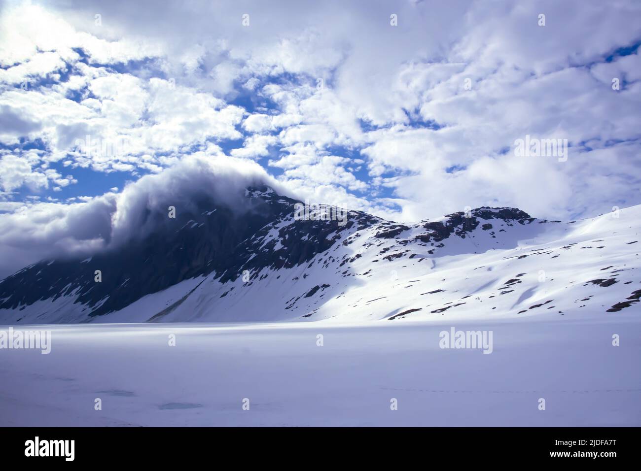 Nubes sobre una montaña cubierta de nieve cerca de Geiringer, Noruega Foto de stock