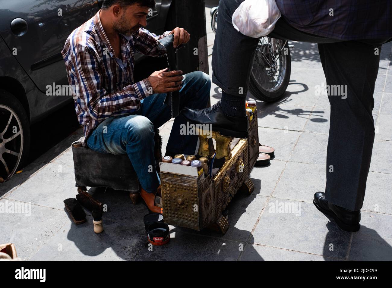 Damasco, Siria - Mayo, 2022: El hombre limpia y pule zapatos en la calle en Damasco, Siria Foto de stock