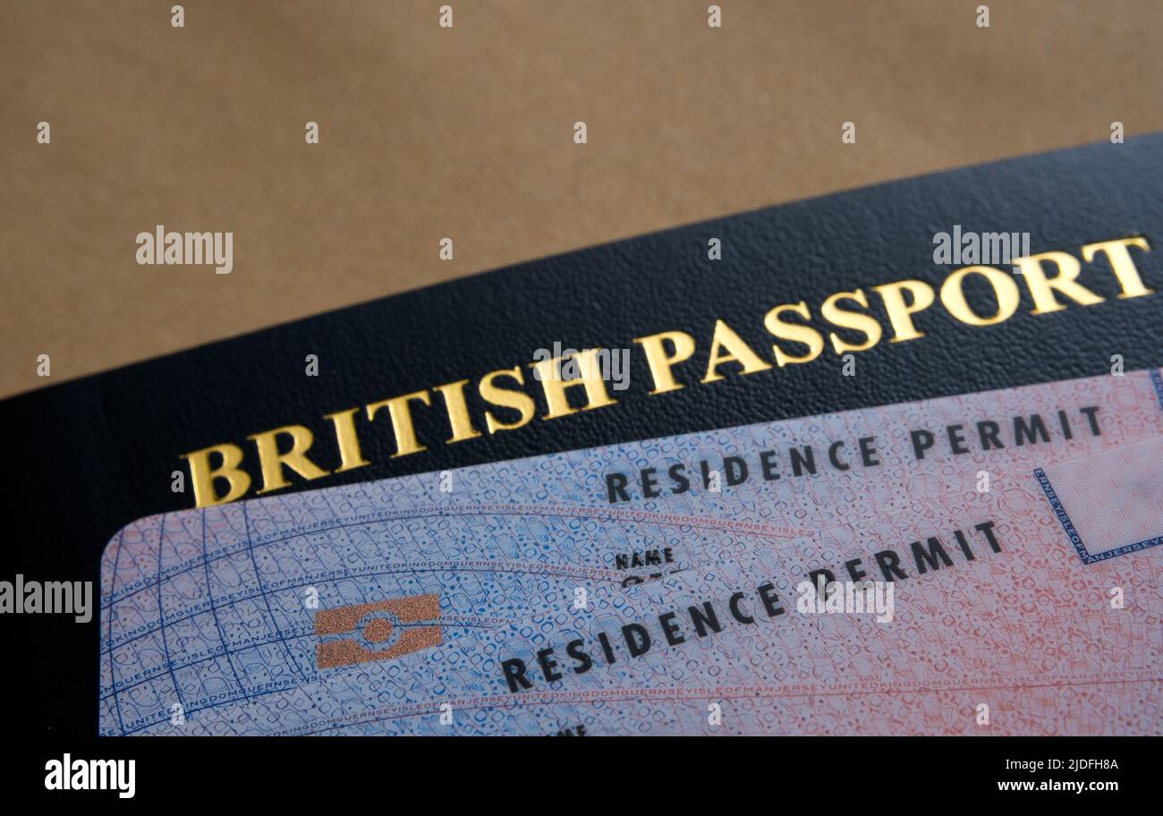 Tarjetas de Permiso de Residencia Biométrica (permiso indefinido para permanecer, ILR) colocadas encima del pasaporte británico. Concepto de naturalización. Stafford, United Kin Foto de stock