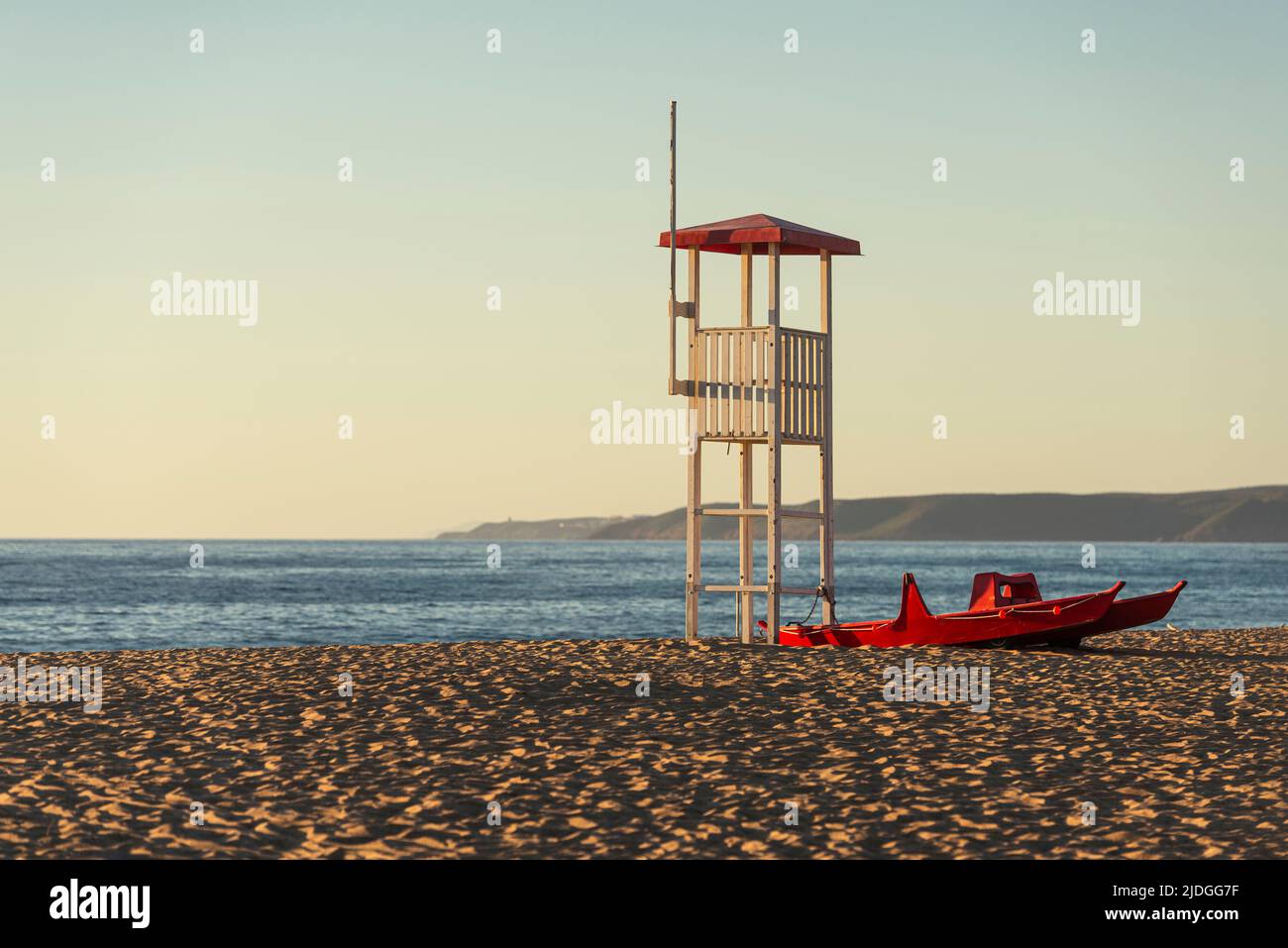Salvataggio socorrista atalaya y barco salvavidas en la playa de arena de las dunas de Piscinas en la luz dorada al atardecer, Costa Verde, Cerdeña, Italia Foto de stock