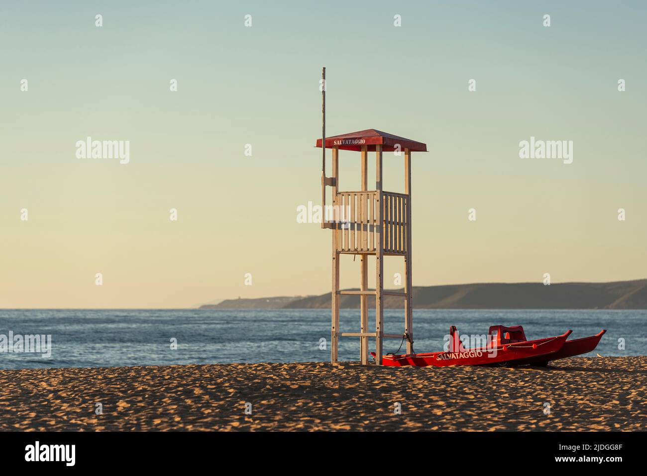 Salvataggio socorrista atalaya y barco salvavidas en la playa de arena de las dunas de Piscinas en la luz dorada al atardecer, Costa Verde, Cerdeña, Italia Foto de stock