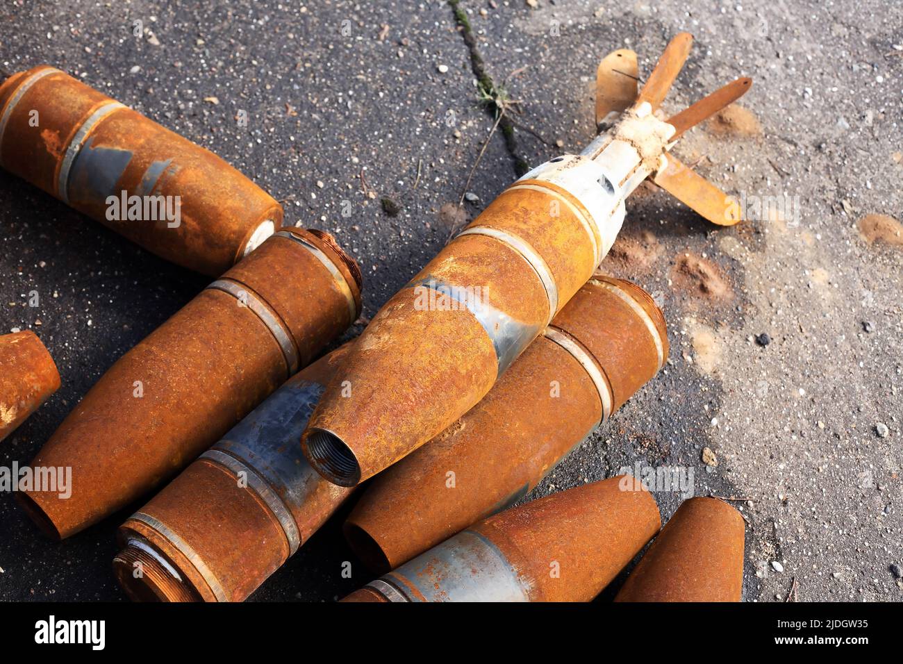 El desperdicio de la guerra. Pocos misiles oxidados usados sobre fondo gris asfalto Foto de stock