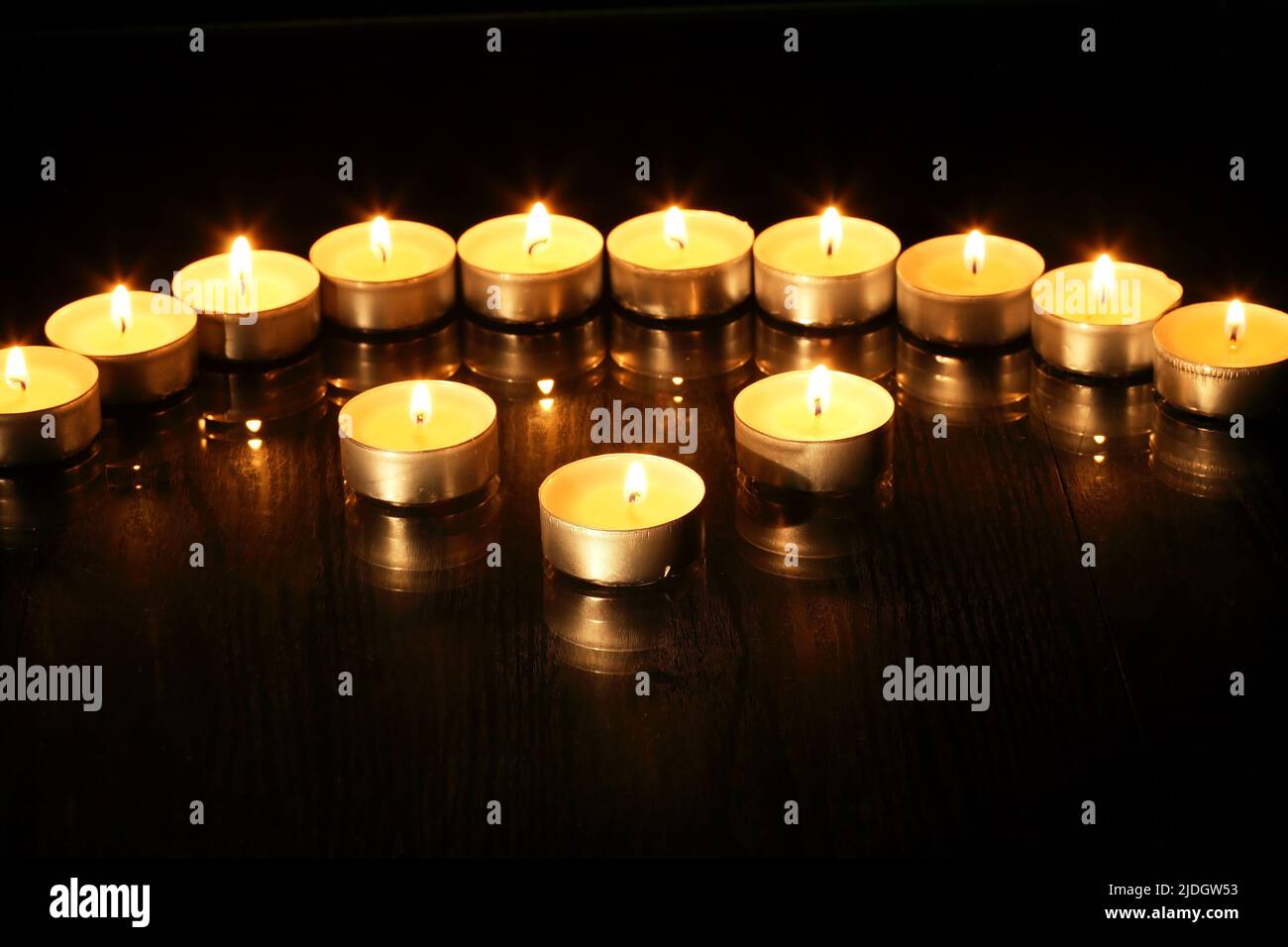 Juego de velas en espiral en una fila contra fondo oscuro Foto de stock