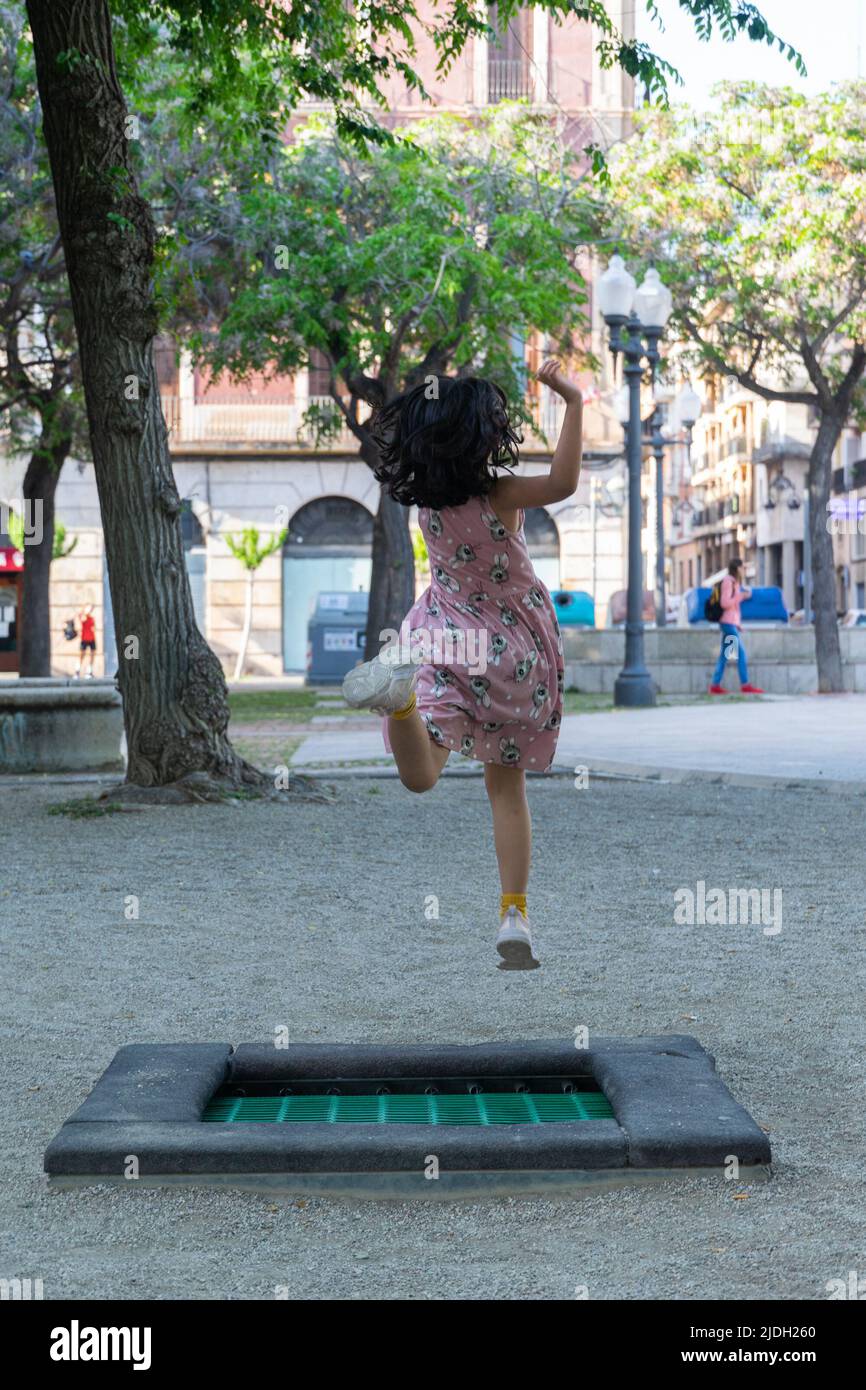 Chica saltando en Plaza de los Carros, Tarragona, España Foto de stock