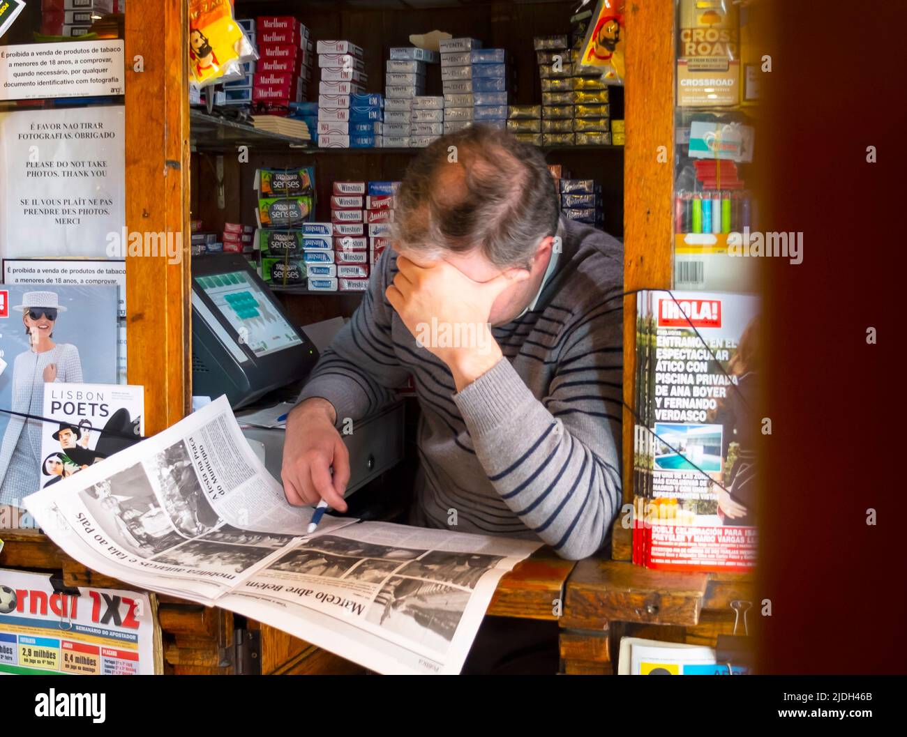 Hombre en el quiosco leyendo un periódico, Portugal, Lisboa Foto de stock